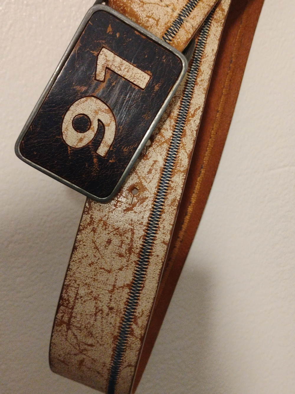 This vintage belt in beige or cream with a textured finish stands out because .